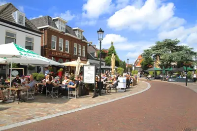 a group of people sitting at tables on a street at Hotel de Duif Lisse - Keukenhof in Lisse