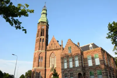 a building with a clock tower on top of it at Hotel de Duif Lisse - Keukenhof in Lisse