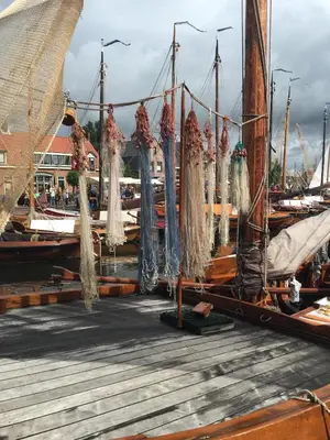 a group of boats tied to a dock with nets at Holiday in Spakenburg Ootje in Spakenburg