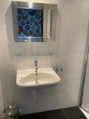 a white bathroom with a sink and a mirror at Holiday in Spakenburg Ootje in Spakenburg