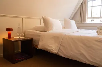 a hotel room with two beds and a window at hotel calisto in Amsterdam