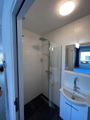 a bathroom with a sink and a shower at Duinroos aan Zee in Egmond aan Zee