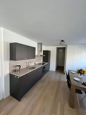 a kitchen with a sink and a table in a room at Duinroos aan Zee in Egmond aan Zee