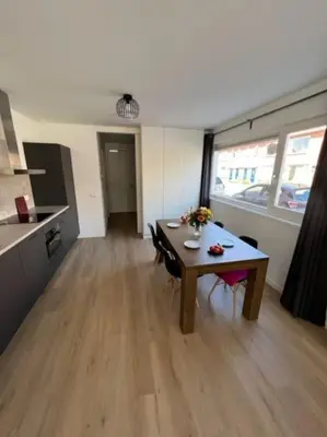 a living room with a table and a kitchen at Duinroos aan Zee in Egmond aan Zee