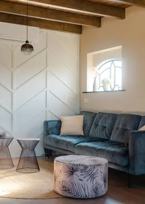 a living room with a blue couch and two tables at Huisje Hartenlust in Bodegraven