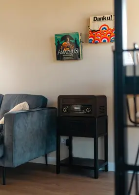 a living room with a couch and a table with a tv at Huisje Hartenlust in Bodegraven