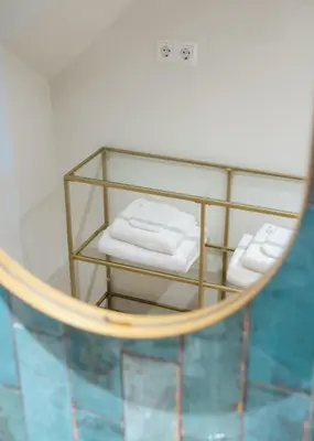 a mirror with two folded towels in a bathroom at Huisje Hartenlust in Bodegraven