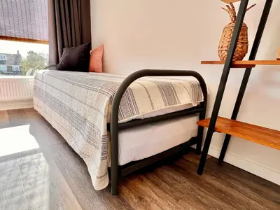 a bed with a black frame in a room at @54 in Zandvoort