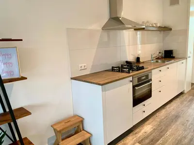 a kitchen with white cabinets and a stove top oven at @54 in Zandvoort