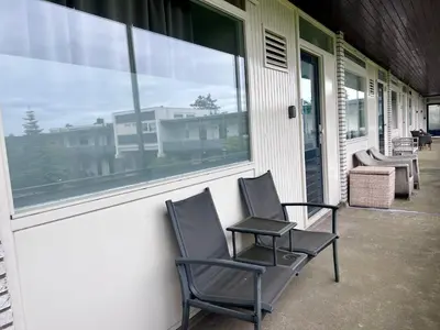 two chairs sitting on a porch next to a window at @54 in Zandvoort