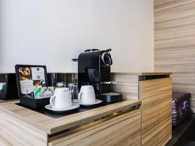 a counter with cups and a coffee maker on it at Novotel Amsterdam City in Amsterdam