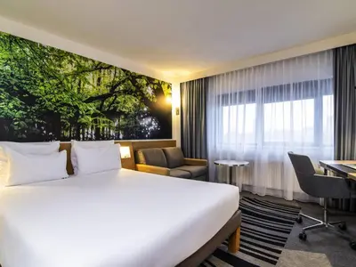 a hotel room with a bed and a desk at Novotel Amsterdam City in Amsterdam