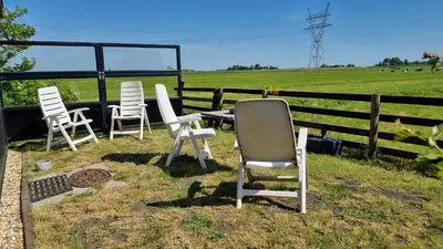 a group of chairs and a table in a field at City Farmers Lodge, a Guesthouse with a skyline view in Rural Amsterdam in Amsterdam