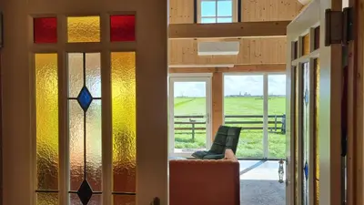 a room with stained glass windows and a chair at City Farmers Lodge, a Guesthouse with a skyline view in Rural Amsterdam in Amsterdam