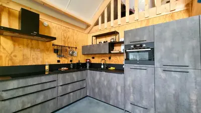 a kitchen with stainless steel appliances and wooden walls at City Farmers Lodge, a Guesthouse with a skyline view in Rural Amsterdam in Amsterdam