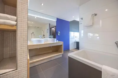 a bathroom with two sinks and a bath tub at Fletcher Hotel-Restaurant Nieuwegein-Utrecht in Nieuwegein