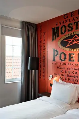 a bedroom with a poster on the wall next to a bed at Inntel Hotels Amsterdam Zaandam in Zaandam