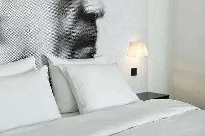 a bed with white pillows and a picture of a man at Inntel Hotels Amsterdam Zaandam in Zaandam