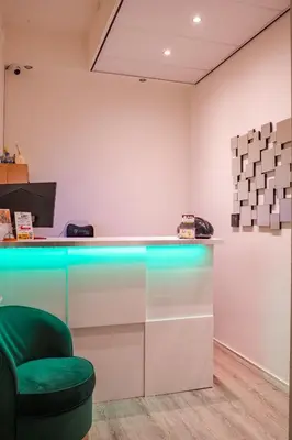 a bar with a green chair in a room at Hotel Kap City Centre in Amsterdam