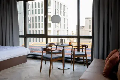 a hotel room with a table and chairs and a large window at Bob W Amsterdam Noord in Amsterdam