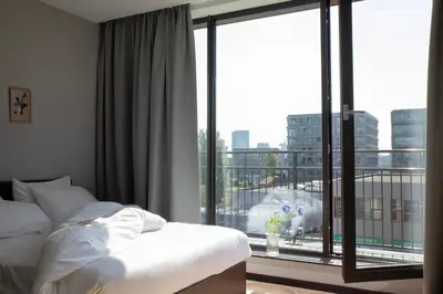 a bedroom with a bed and a large window at Bob W Amsterdam Noord in Amsterdam