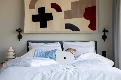 a child laying on a bed with a laptop at Bob W Amsterdam Noord in Amsterdam