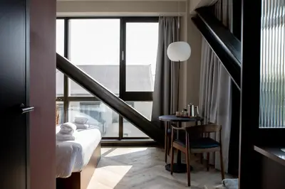 a hotel room with a bed and a table and a window at Bob W Amsterdam Noord in Amsterdam