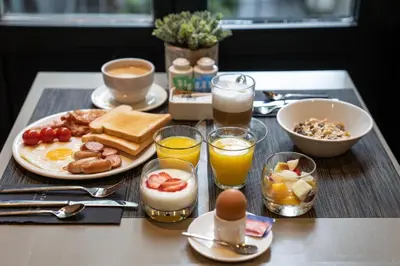 a breakfast table with breakfast foods and drinks on a table at Catalonia Vondel Amsterdam in Amsterdam