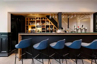 a bar with blue chairs in a room at Catalonia Vondel Amsterdam in Amsterdam