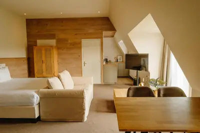 a living room with a couch and a table at Strandhotel Camperduin in Schoorl