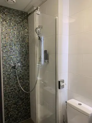 a shower with a glass door in a bathroom at Hotel De Looier in Amsterdam