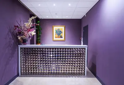 a hallway with purple walls and a vase of flowers at Hotel De Looier in Amsterdam