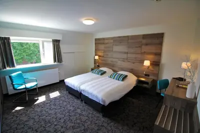 a hotel room with a bed and a wooden headboard at Het Wapen van Harmelen in Harmelen