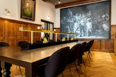 a conference room with a table and chairs in front of a large painting at Hotel Die Port van Cleve in Amsterdam