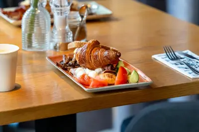 a plate of food sitting on a wooden table at Hotel Die Port van Cleve in Amsterdam