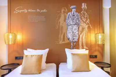 two beds in a hotel room with a painting on the wall at Hotel Die Port van Cleve in Amsterdam