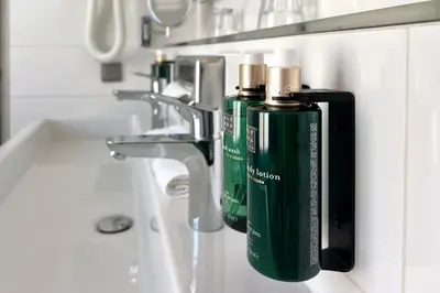 a bathroom with two green bottles on a sink at Hotel Die Port van Cleve in Amsterdam