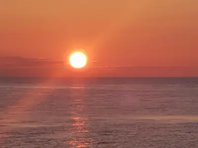 a sunset over the ocean with the sun in the sky at Luxury loft at lake Volendam 20 min. from Amsterdam CS in Volendam