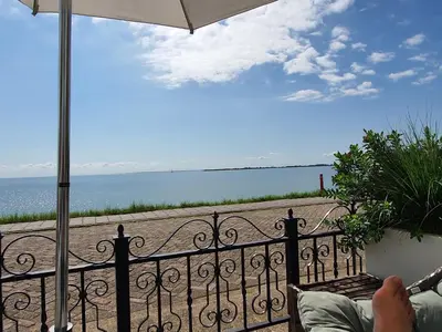 a person sitting on a balcony looking out at the ocean at Luxury loft at lake Volendam 20 min. from Amsterdam CS in Volendam