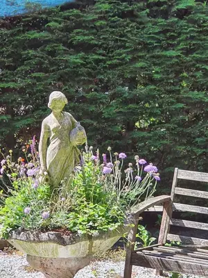 a statue in a flower pot next to a bench at Luxury loft at lake Volendam 20 min. from Amsterdam CS in Volendam