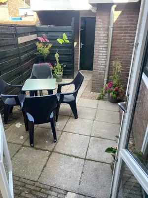 a patio with a table and chairs and plants at Het Popelhuisje in Alkmaar