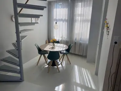 a dining room with a table and chairs and a staircase at Het Popelhuisje in Alkmaar