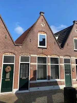 a brick building with green doors and windows at Het Popelhuisje in Alkmaar