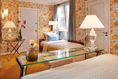 a hotel room with two beds and a glass table at Hotel Estheréa in Amsterdam