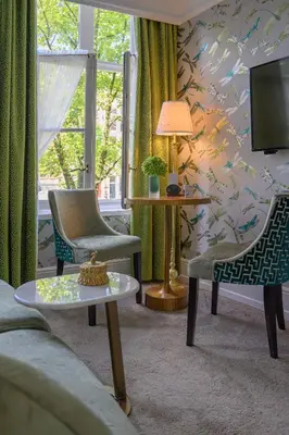 a living room with two chairs and a tv at Hotel Estheréa in Amsterdam