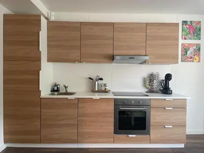 a kitchen with wooden cabinets and a stove at Zee En Meer in Egmond aan Zee
