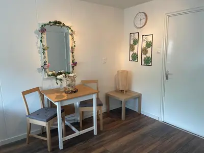 a dining room with a table and a mirror at Zee En Meer in Egmond aan Zee
