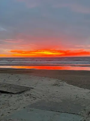 a sunset on a beach with the ocean at Zee En Meer in Egmond aan Zee
