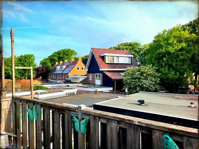 a house with butterflies on a wooden fence at Zee En Meer in Egmond aan Zee