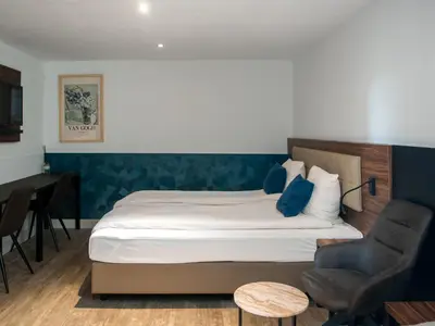 a bedroom with a bed and a desk and a chair at Amsterdam Lake Hotel in Badhoevedorp